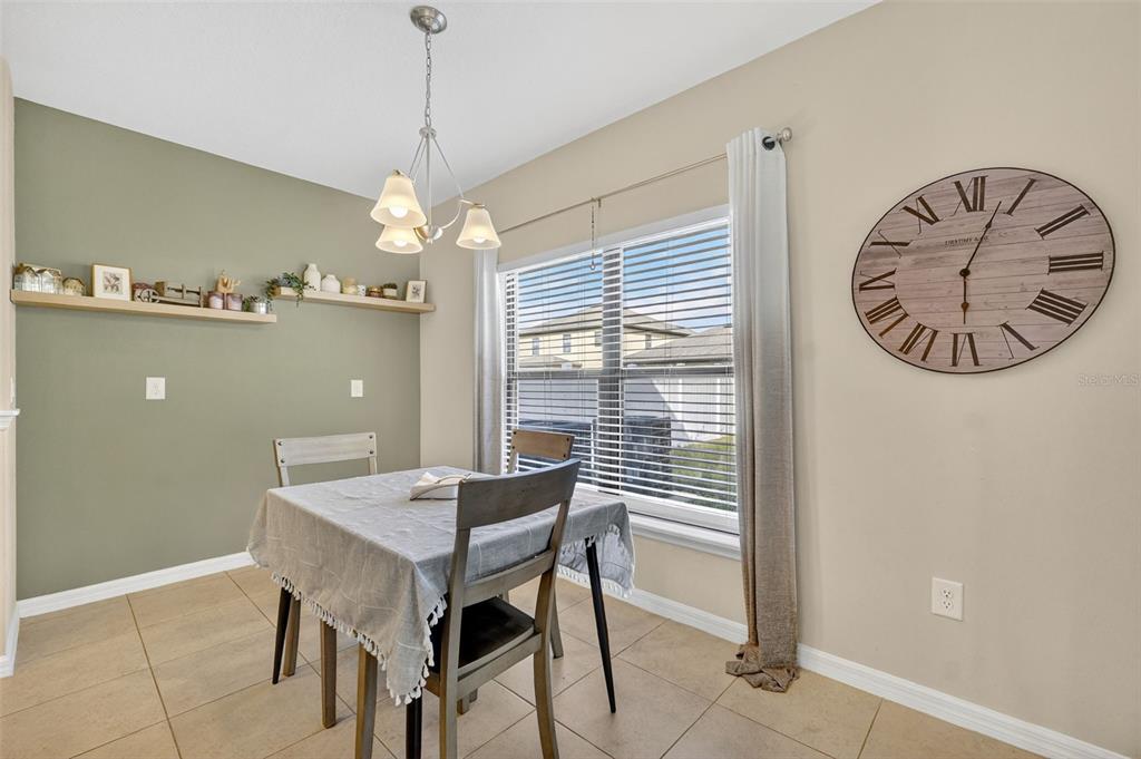 11214 Carrick Stone Street Wimauma, FL 33598 - Photo 24 of 73 a view of a dining room with furniture and window