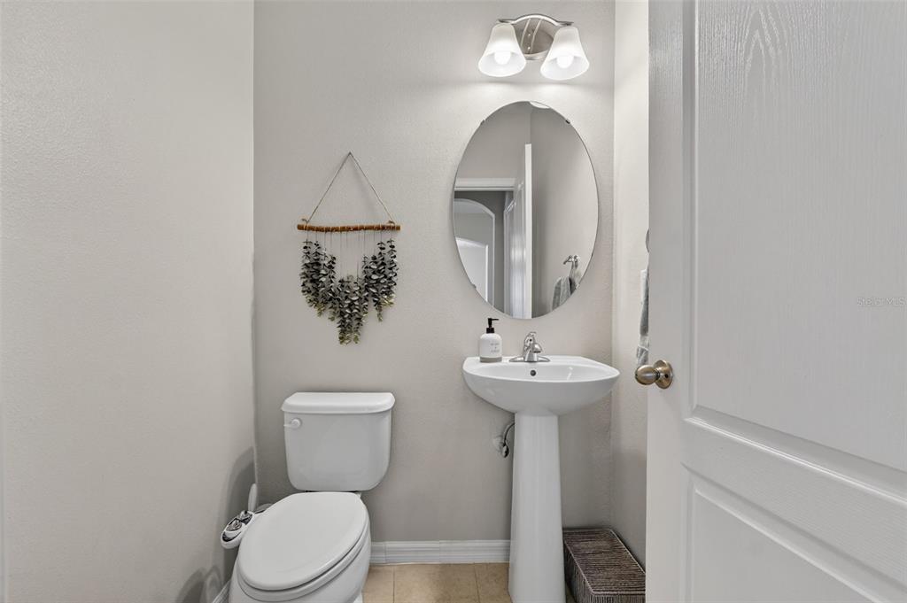 11214 Carrick Stone Street Wimauma, FL 33598 - Photo 28 of 73 a bathroom with a toilet sink and mirror