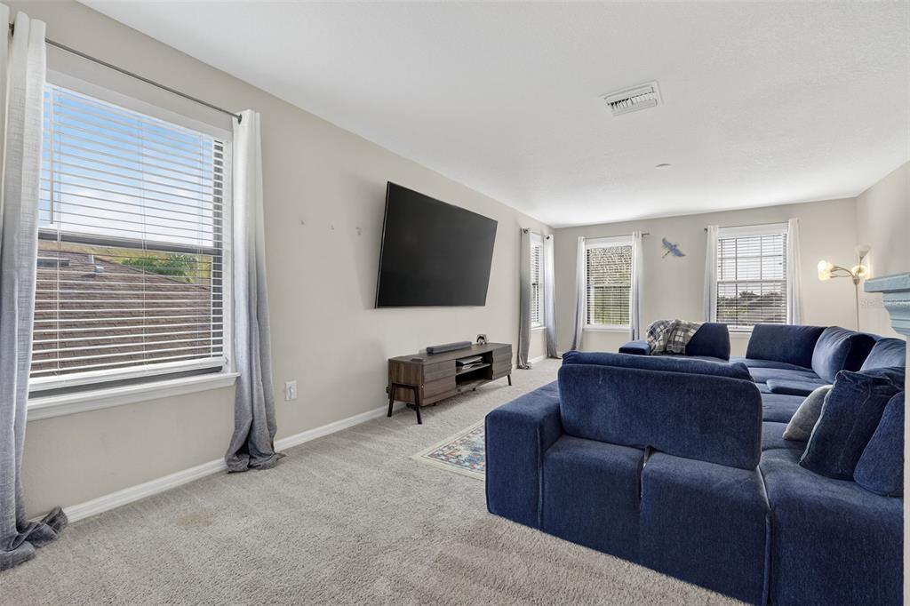 11214 Carrick Stone Street Wimauma, FL 33598 - Photo 32 of 73 a living room with furniture and a flat screen tv