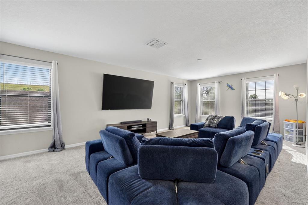 11214 Carrick Stone Street Wimauma, FL 33598 - Photo 33 of 73 a living room with furniture and a flat screen tv