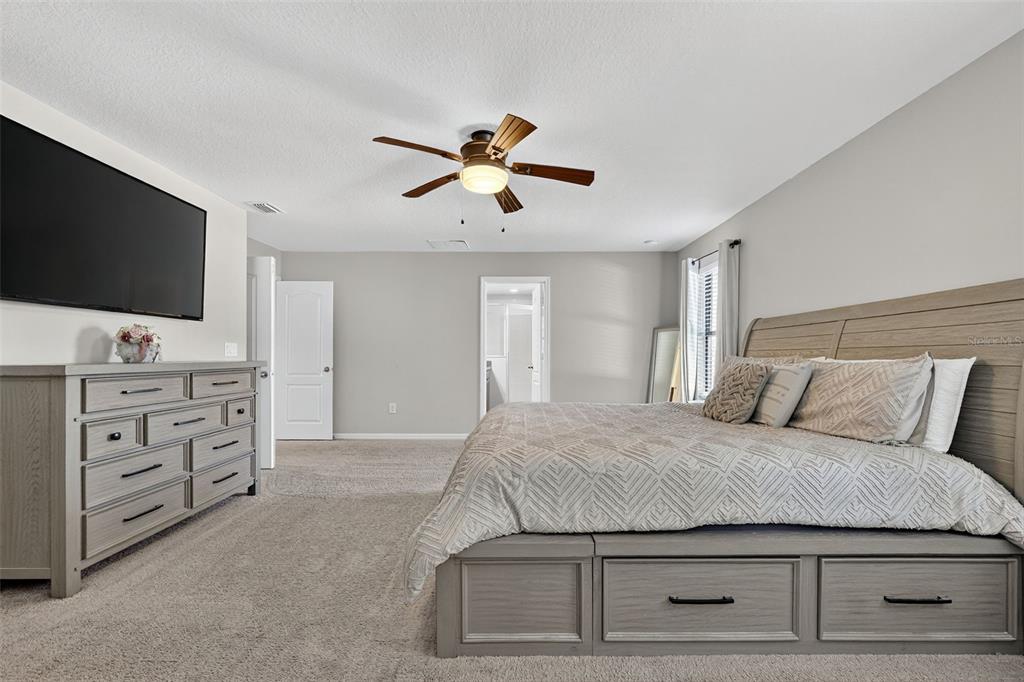 11214 Carrick Stone Street Wimauma, FL 33598 - Photo 37 of 73 a bedroom with a bed and a flat screen tv