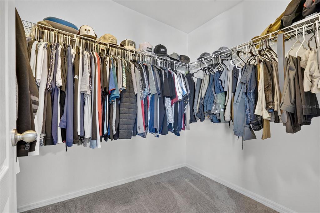 11214 Carrick Stone Street Wimauma, FL 33598 - Photo 40 of 73 a view of walk in closet with clothes