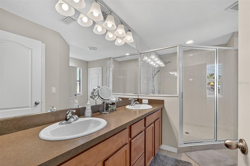 11214 Carrick Stone Street Wimauma, FL 33598 - Photo 41 of 73 a bathroom with a sink double vanity and a mirror