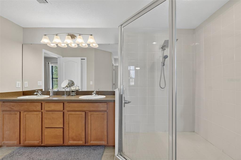 11214 Carrick Stone Street Wimauma, FL 33598 - Photo 42 of 73 a bathroom with a double vanity sink and a mirror