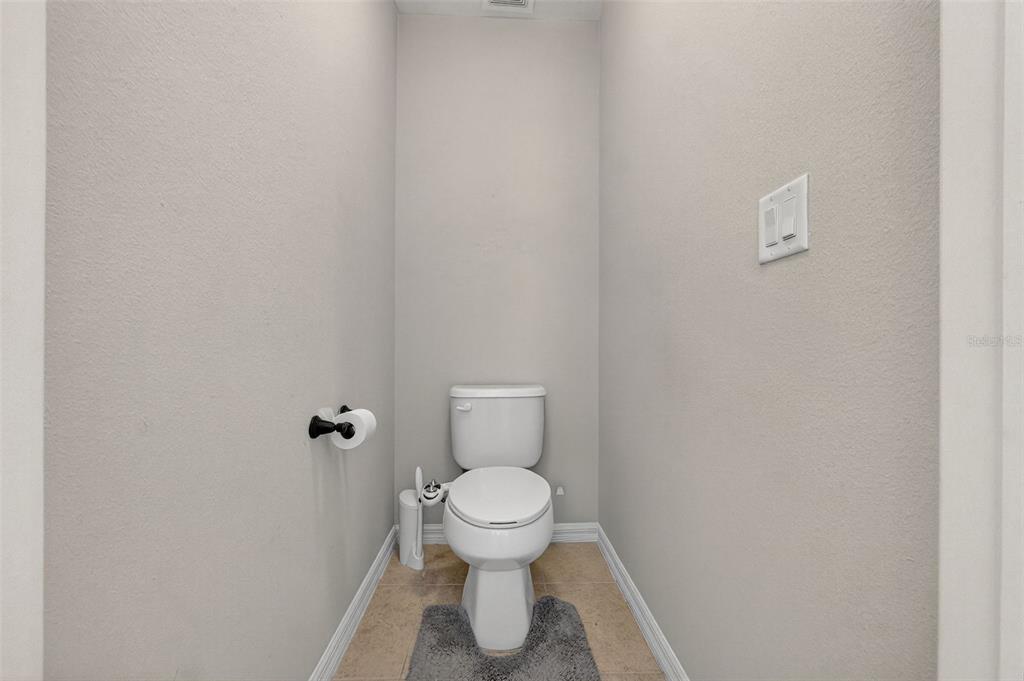 11214 Carrick Stone Street Wimauma, FL 33598 - Photo 43 of 73 a white toilet sitting in a bathroom