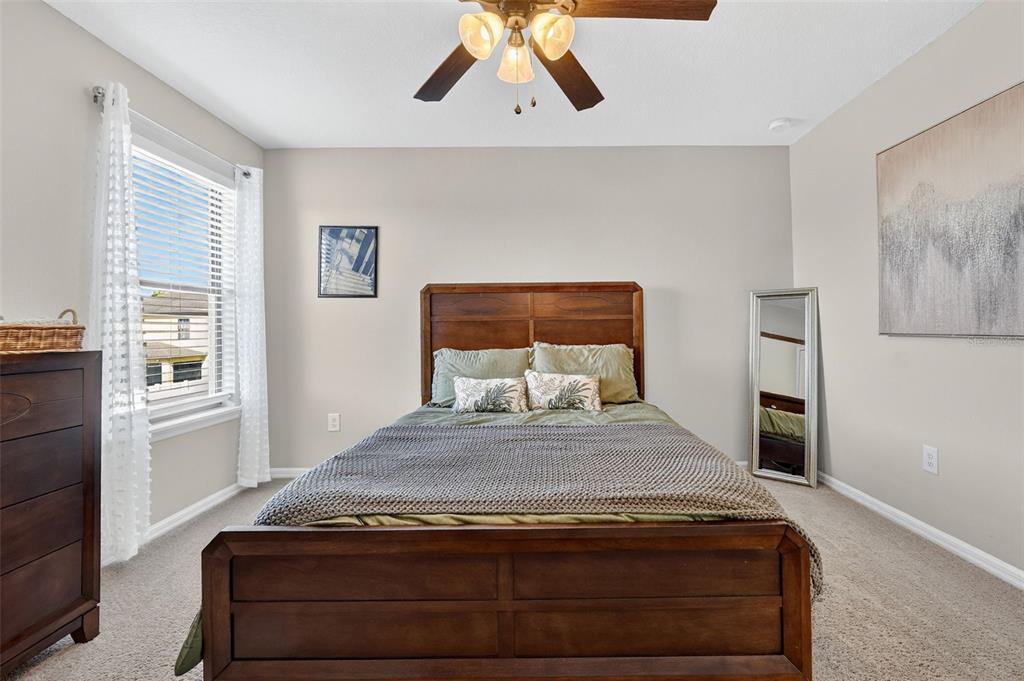 11214 Carrick Stone Street Wimauma, FL 33598 - Photo 45 of 73 a bedroom with a bed and wooden floor