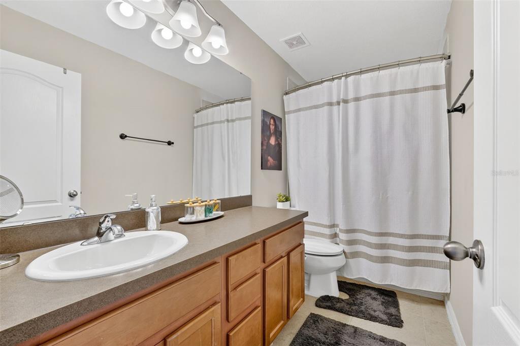 11214 Carrick Stone Street Wimauma, FL 33598 - Photo 46 of 73 a bathroom with a double vanity sink mirror and toilet