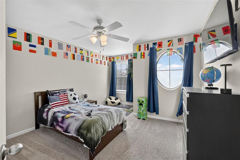 11214 Carrick Stone Street Wimauma, FL 33598 - Photo 47 of 73 a bedroom with bed and a mirror