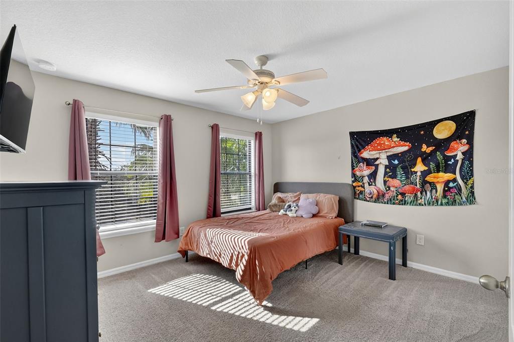 11214 Carrick Stone Street Wimauma, FL 33598 - Photo 49 of 73 a bedroom with a bed and a painting on the wall
