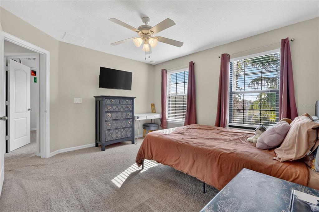 11214 Carrick Stone Street Wimauma, FL 33598 - Photo 50 of 73 a bedroom with a bed and a television