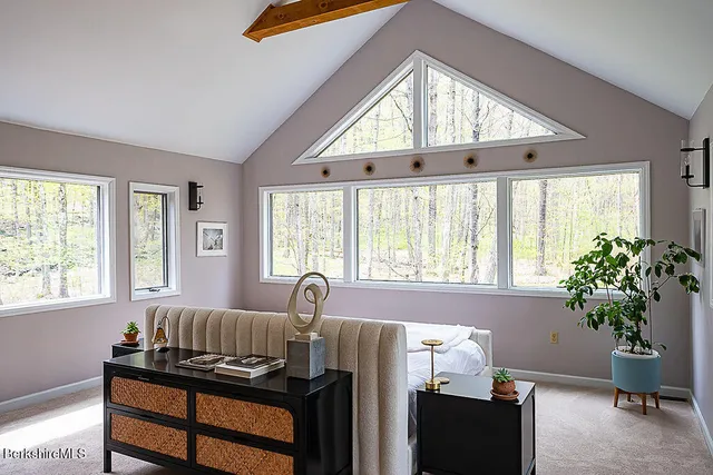 a bed sitting in a bedroom next to a window