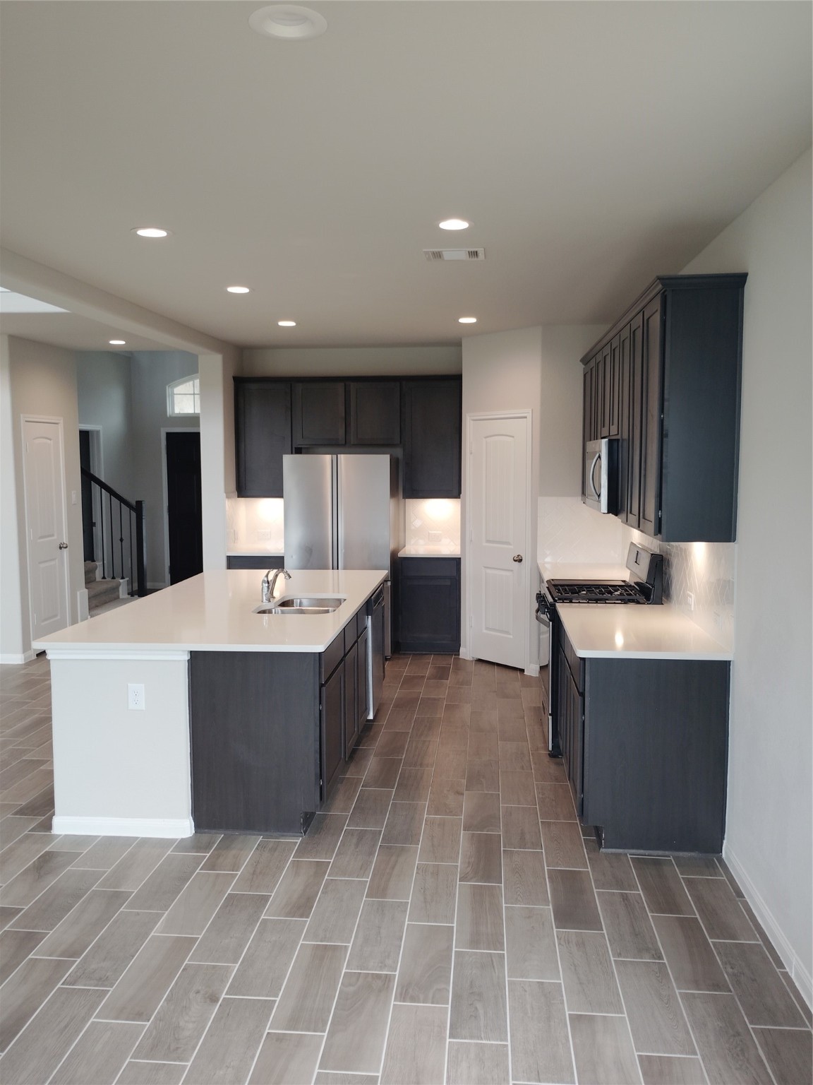 85 Carmel Drive Manvel, TX 77578 - Photo 16 of 31 a large kitchen with kitchen island a sink a counter top and oven