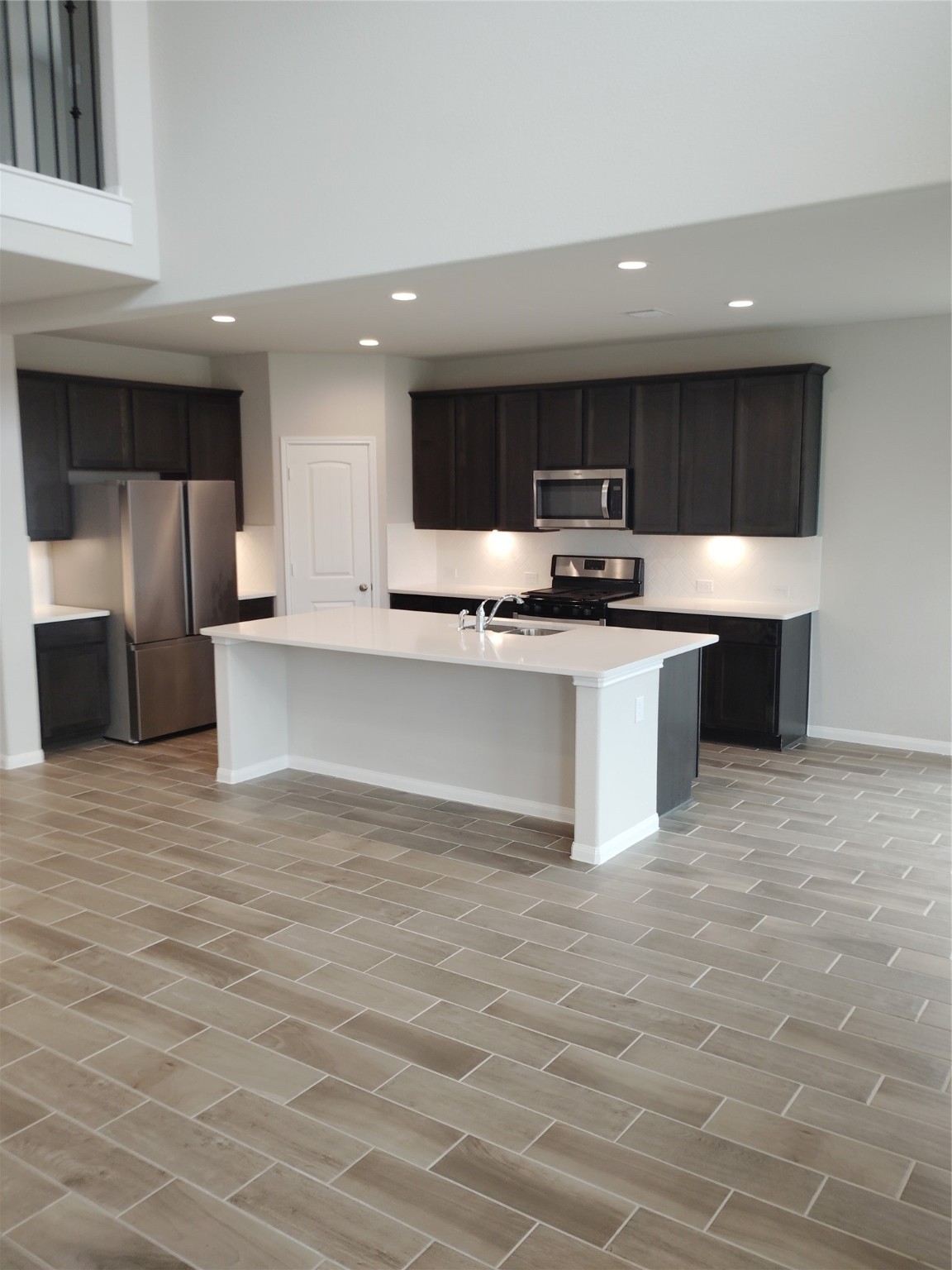 85 Carmel Drive Manvel, TX 77578 - Photo 19 of 31 a kitchen with stainless steel appliances a sink a stove a microwave and cabinets