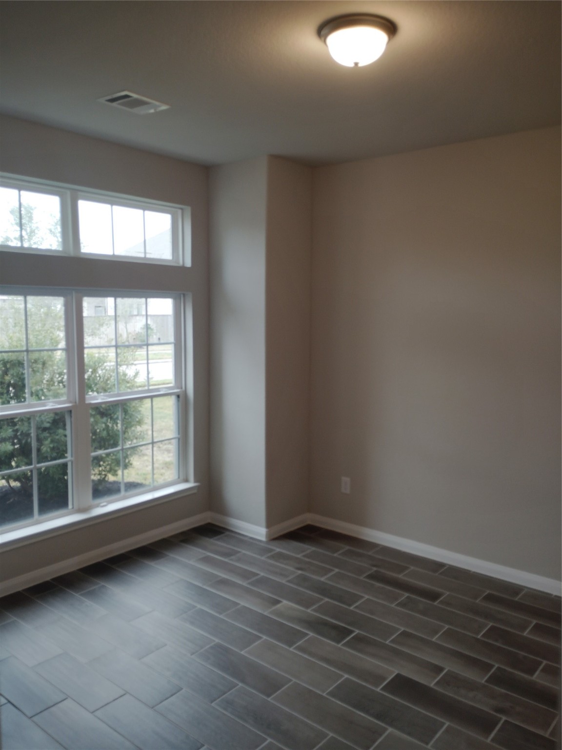 85 Carmel Drive Manvel, TX 77578 - Photo 23 of 31 an empty room with wooden floor and windows