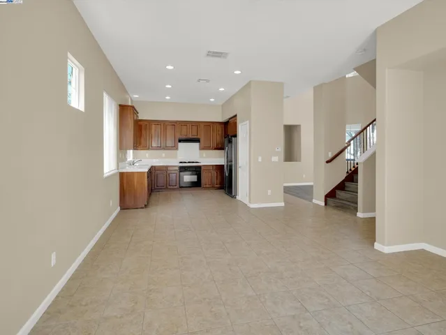 a living room with stainless steel appliances furniture a rug and a window