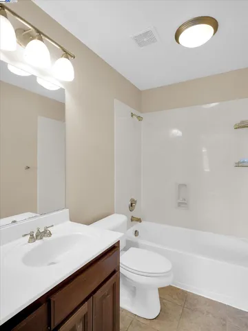 a bathroom with a toilet a sink a tub and mirror