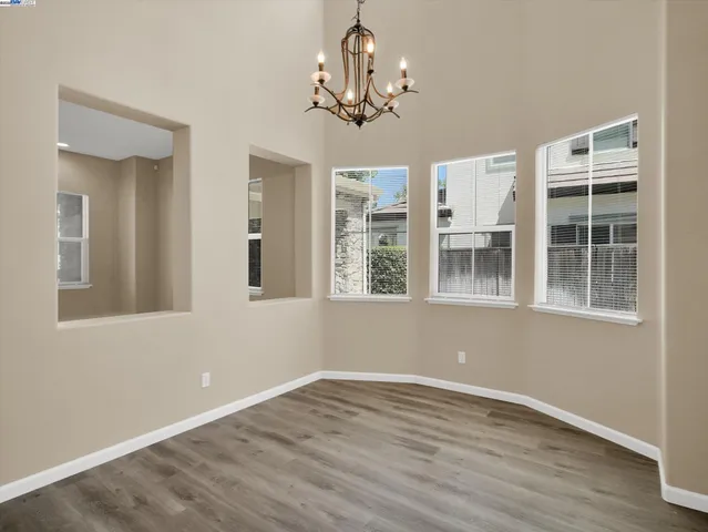 a view of empty room with wooden floor and windows