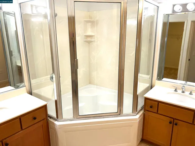 a bathroom with a tub a sink a mirror and a shower