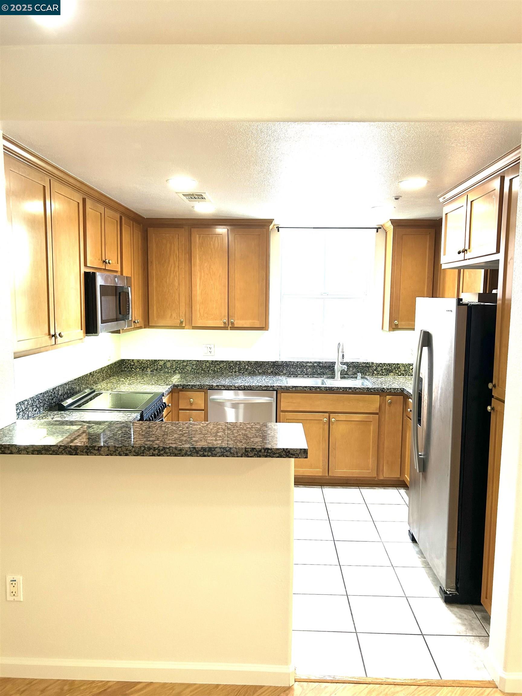 1310 Saddle Rack Street, Unit 352 San Jose, CA 95126 - Photo 4 of 41 a kitchen with granite countertop a refrigerator and a stove