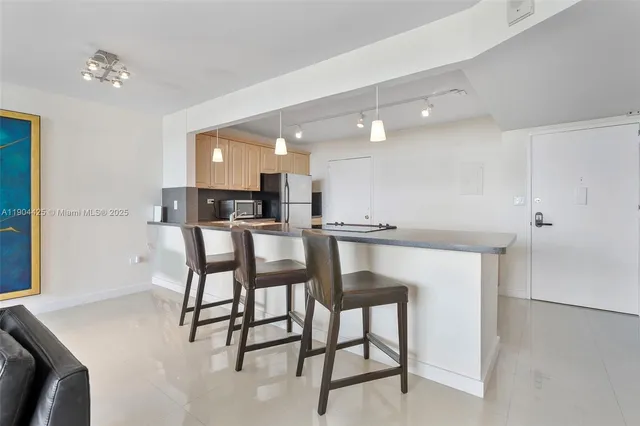 a kitchen with a table chairs and white cabinets