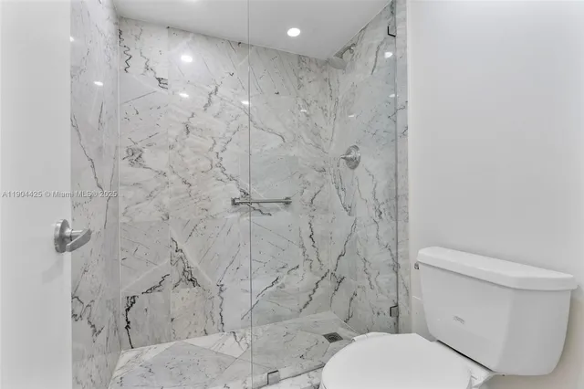 a bathroom with a toilet and a shower