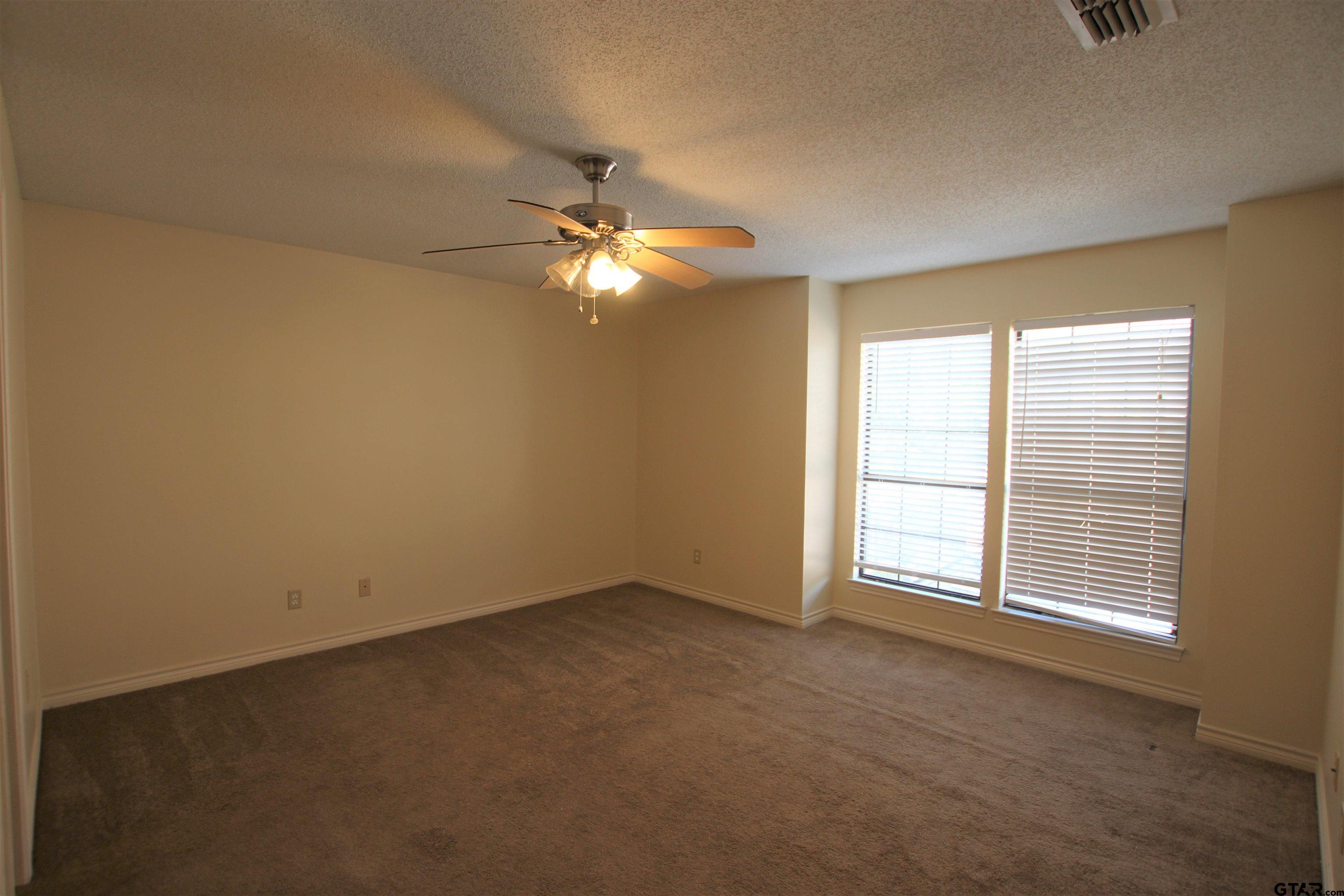 5875 Creekside Circle Tyler, TX 75703 - Photo 19 of 32 an empty room with windows and fan