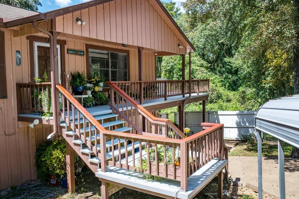 a view of a house with wooden deck and a chair