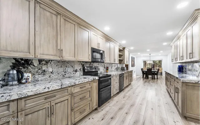 a en suite bathroom with a granite countertop double vanity sink and mirror
