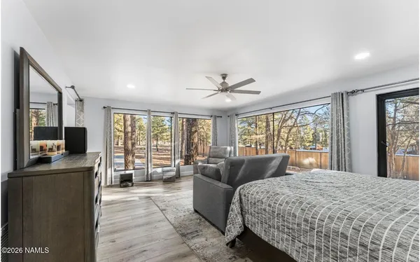 a bed sitting in a bedroom next to a bathroom with a shower curtain