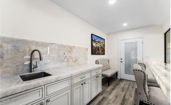 a bathroom with a granite countertop sink a toilet a mirror and shower