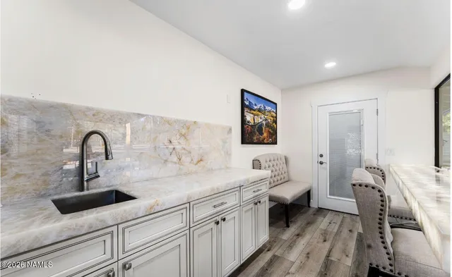 a bathroom with a granite countertop sink a toilet a mirror and shower