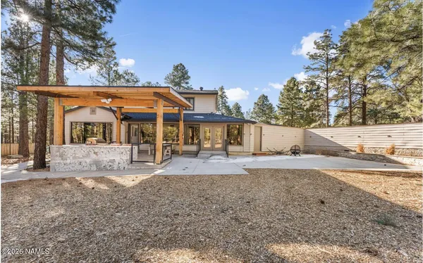 a white house that has tree in front of it