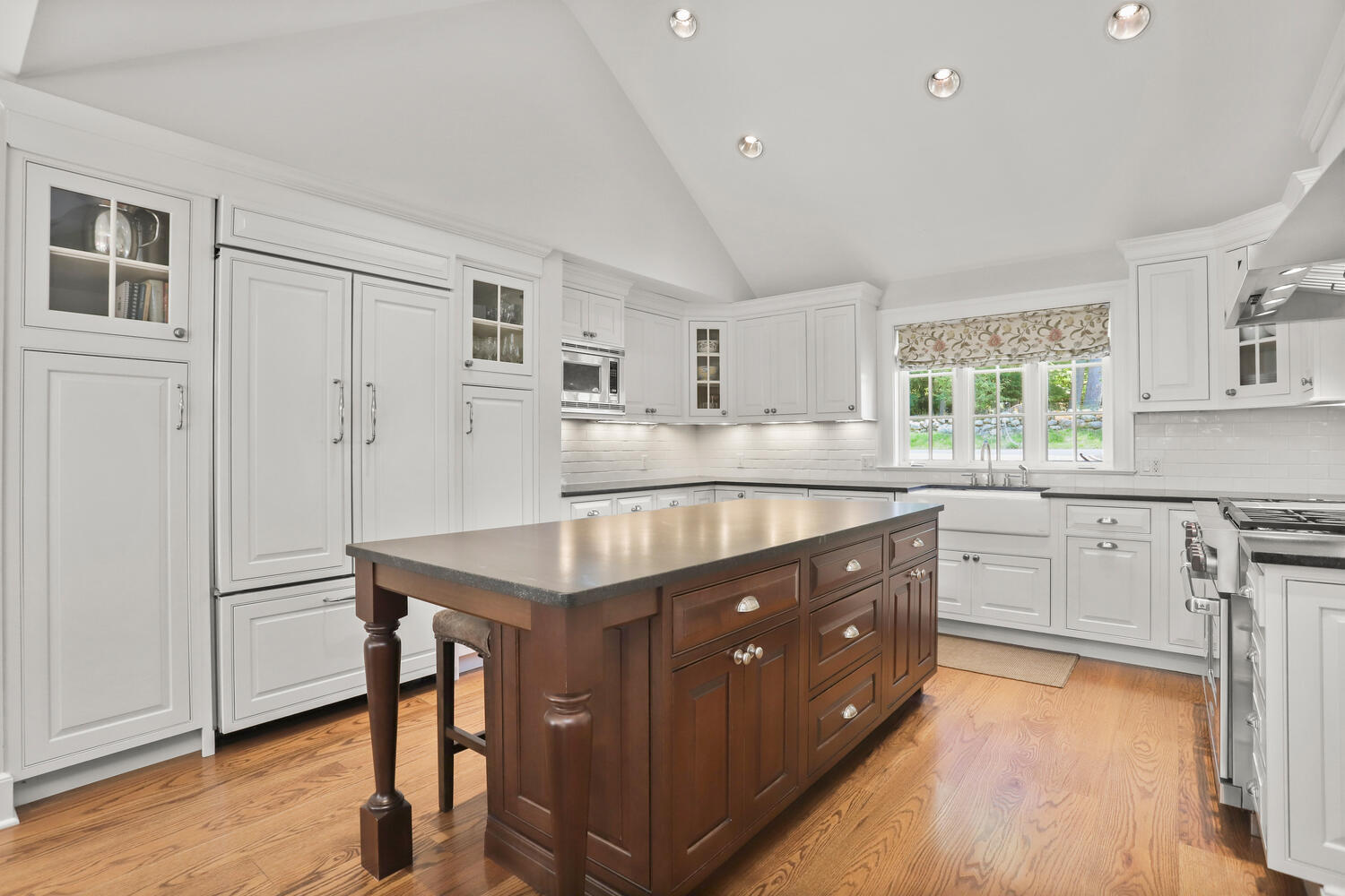 538 Laurel Road New Canaan, CT 06840 - Photo 4 of 28 a kitchen with a stove a sink a dining table and chairs