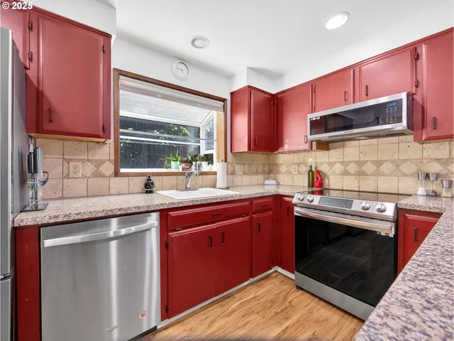 a kitchen with stainless steel appliances granite countertop a sink stove and cabinets