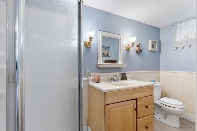 a bathroom with a toilet a sink and mirror