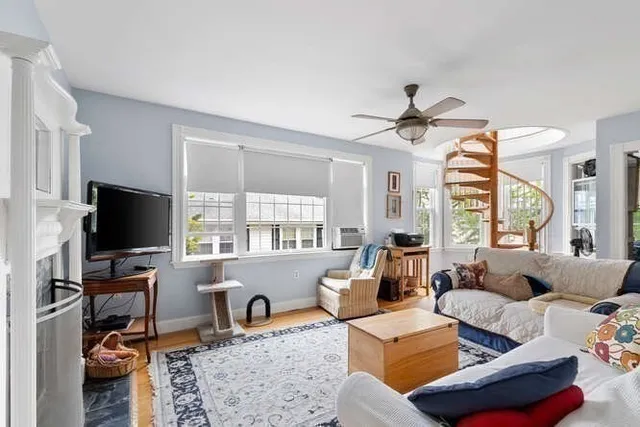 a living room with furniture a flat screen tv and a large window