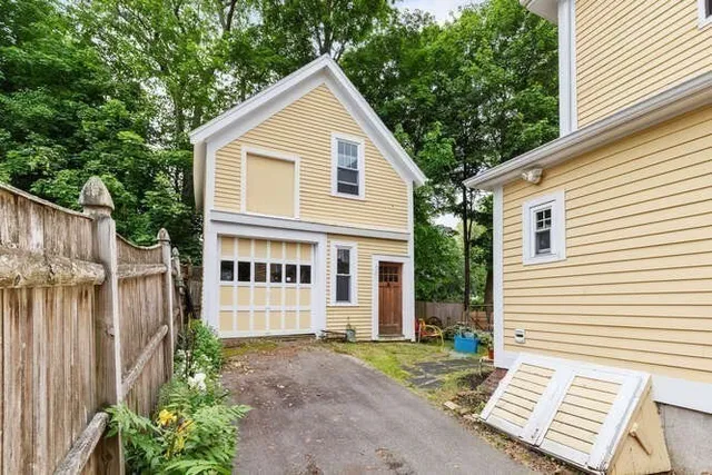 a view of a house with a yard and wooden fence