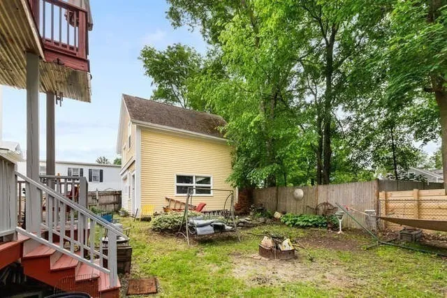 a backyard of a house with barbeque oven and fence