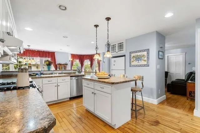 a kitchen with granite countertop a sink a counter space appliances and cabinets
