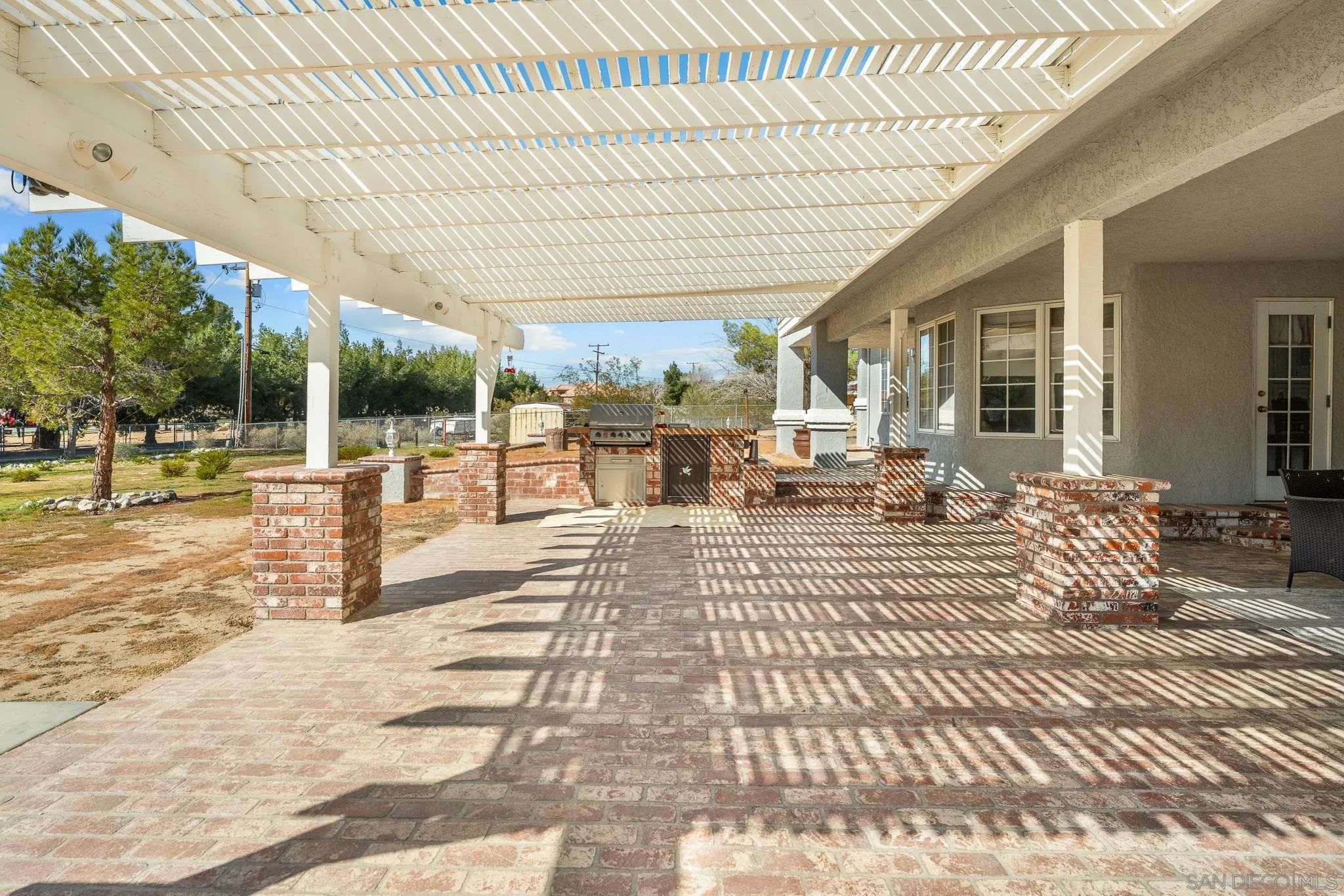 19775 Symeron Road Apple Valley, CA 92307 - Photo 60 of 73 a view of a patio with dining table and chairs with wooden floor and fence