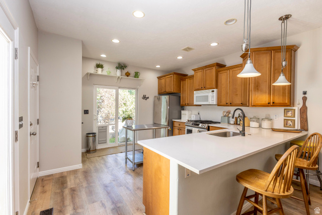 11751 Lake Run Road South Jordan, UT 84009 - Photo 12 of 38 Contemporary kitchen featuring light wood-finish flooring and a white solid surface countertop
