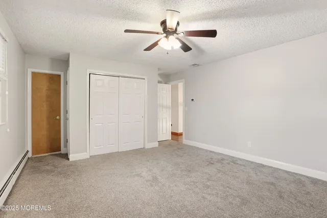 an empty room with windows and fan