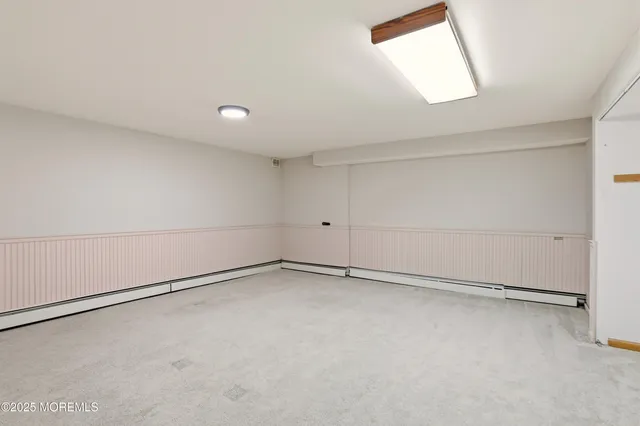a view of an empty room with closet and windows