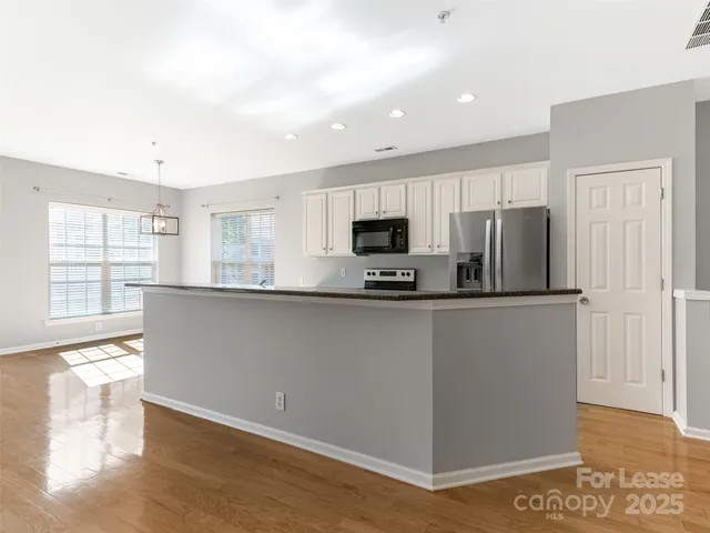 a kitchen with stainless steel appliances a refrigerator sink and microwave