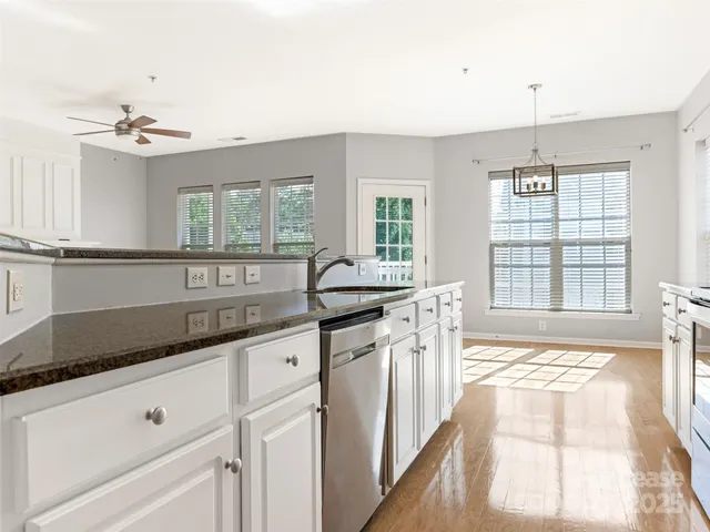 a kitchen with granite countertop stainless steel appliances sink and window
