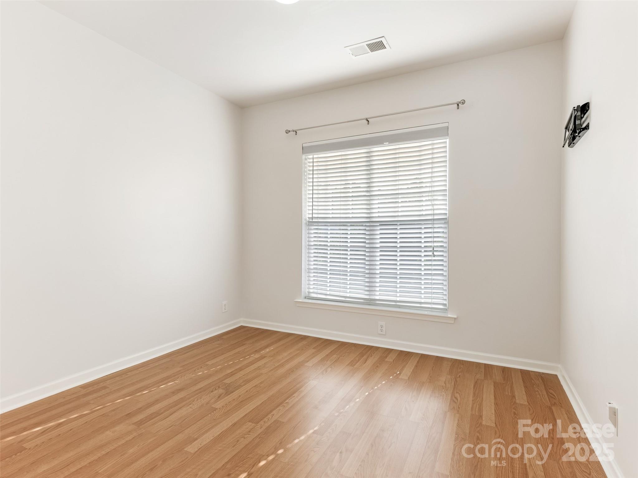 3164 Margellina Drive Charlotte, NC 28210 - Photo 18 of 26 a view of an empty room with wooden floor and a window