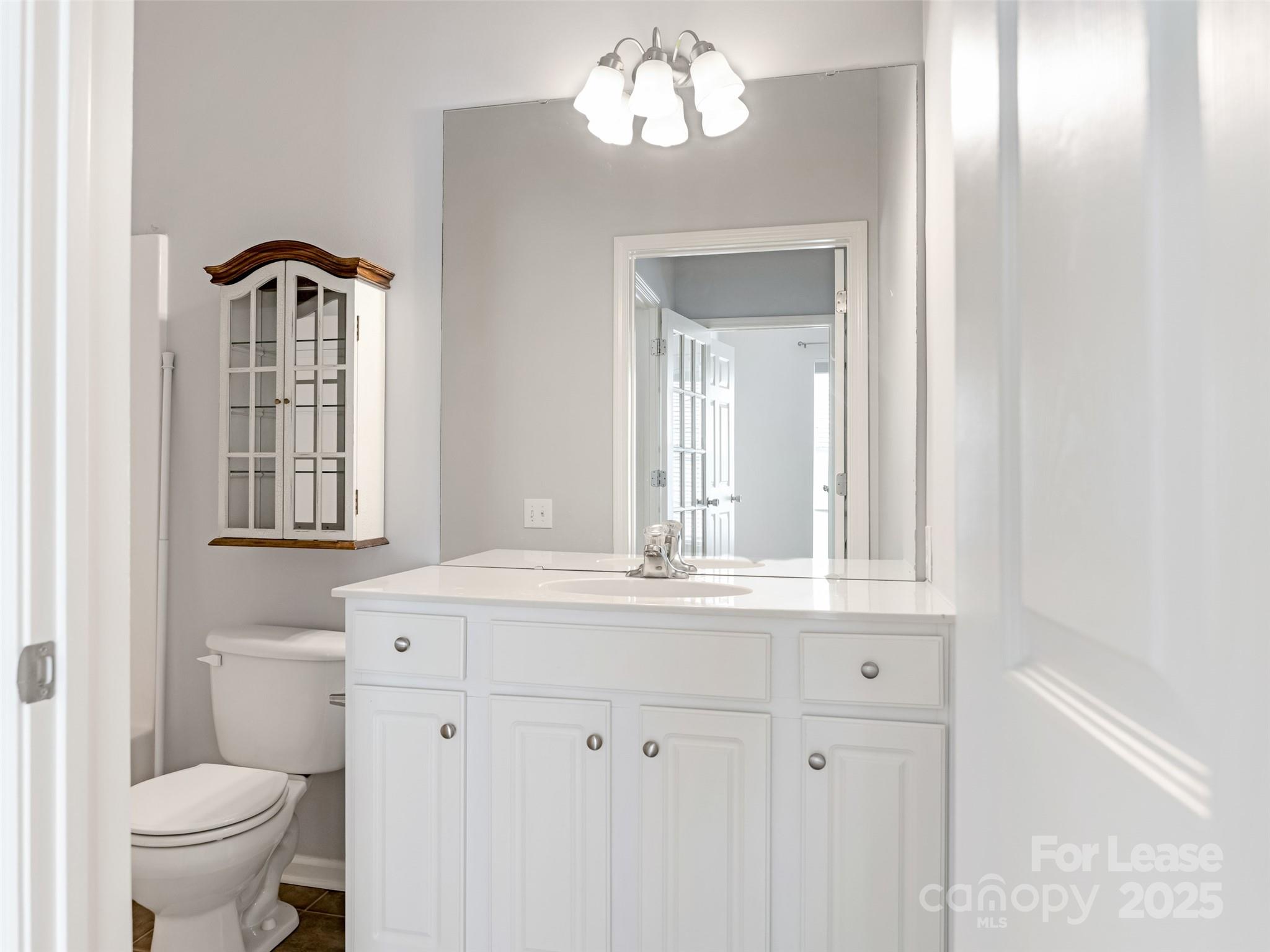 3164 Margellina Drive Charlotte, NC 28210 - Photo 21 of 26 a bathroom with a granite countertop toilet a sink and a mirror