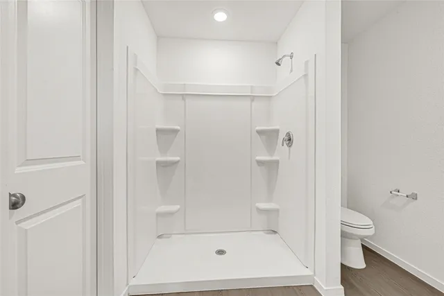 a bathroom with a toilet and a shower
