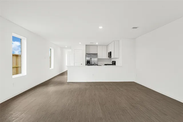 a view of large kitchen with wooden floor and windows