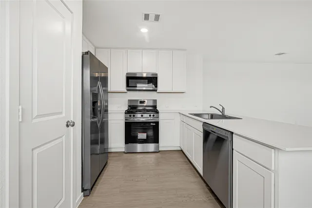 a kitchen with stainless steel appliances a refrigerator stove and sink